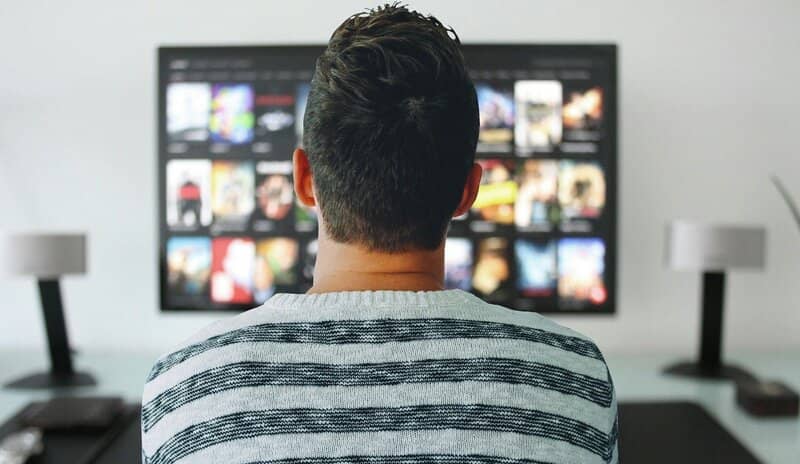 Hombre revisando el catálogo de Netflix en la televisión