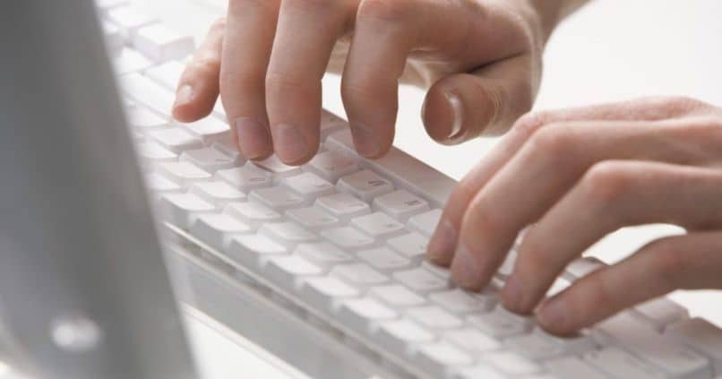 manos escribiendo en el teclado mac